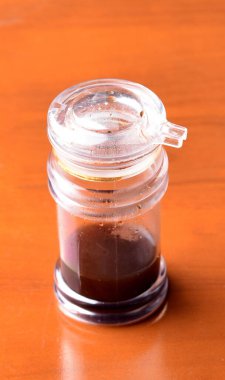 Ahşap masada sos şişesi.