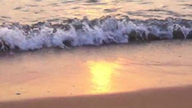 Plajda gün batımını yansıtan deniz sörfü, Pattaya plajı.