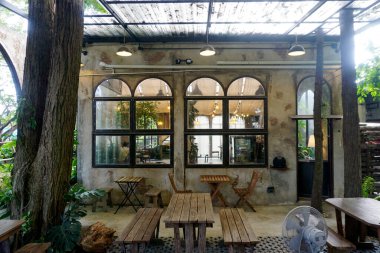 CHONBURI, THAILAND - 10 SEP: 10 Eylül 2024 tarihinde Pattaya, Chonburi, Tayland 'da masa ve koltuk altında pencere olan vintage duvar