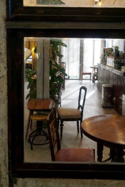 Kafedeki masa ve sandalye, pencere camından bakıyor.