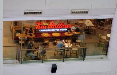 BANGKOK, THAILAND - 19 DEC: Tim Hortons kahve dükkanının atmosferi 19 Aralık 2024 'te Bangkok, Tayland' daki alışveriş merkezindeki kafenin camından bakıyor 