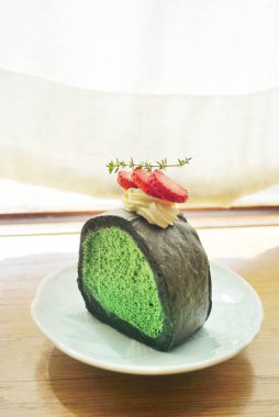 Ahşap masada kibrit yeşil çay köpüklü kek.