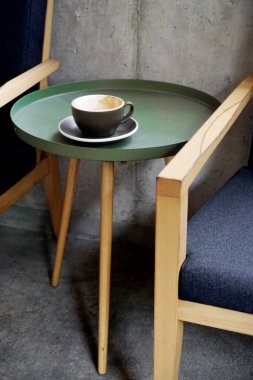 Boş kahve fincanı masada, yanında sandalye var.