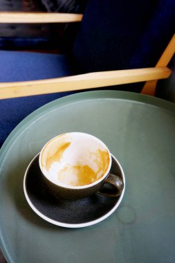 Boş kahve fincanı yanında sandalye, dinlenme yeri kafede.