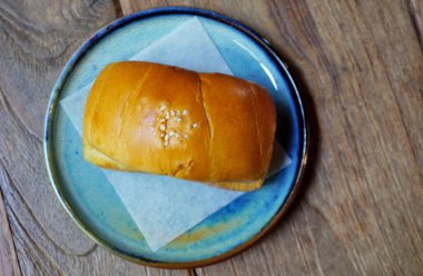 Ahşap masa manzaralı mavi tabakta tuzlu ekmek