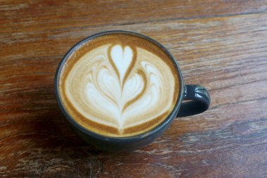 Latte art ahşap masa tarih ile kahve fincanı