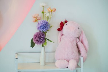 El işi çiçek ve rafta pembe tavşan kapısı, hoş renkli iç mekan. 