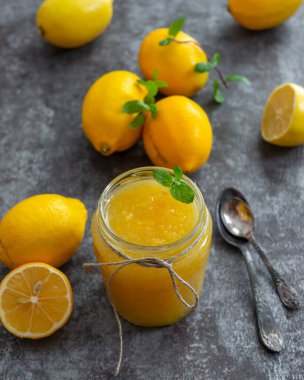 Cam kavanozlarda taze ev yapımı limon reçeli. Olgun limonlu masa ayarları