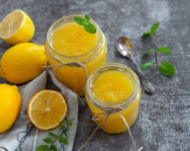 Cam kavanozlarda taze ev yapımı limon reçeli. Olgun limonlu masa ayarları