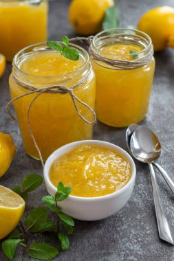 Cam kavanozlarda taze ev yapımı limon reçeli. Olgun limonlu masa ayarları