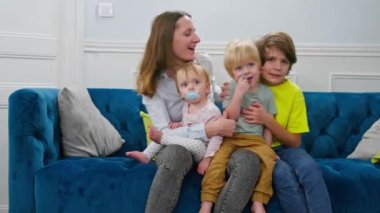 Aile: iki oğlu ve bir kızı olan anne evde oturup koçun önünde oynaşıyor.