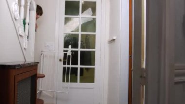 Genç bir çocuk merdivenlerden eve iniyor.