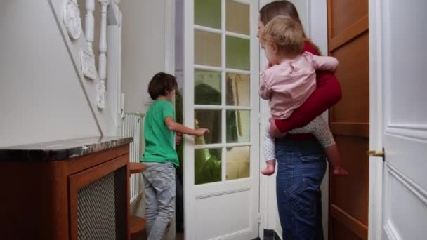 Kobieta Dziećmi Otwarte Drzwi Dla Ojca Przynosząc Choinkę Domu — Wideo stockowe