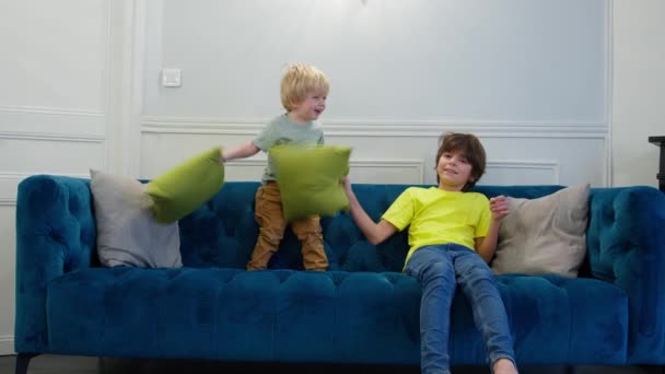 Walka Poduszki Dwóch Chłopców Bawi Się Poduszkami Siedzącymi Razem Kanapie — Wideo stockowe