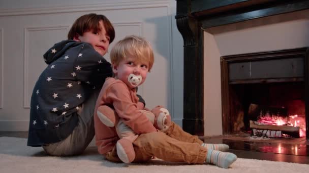 Dwóch Chłopców Dostaje Ciepłe Siedzieć Przed Kominkiem Domu Zimą — Wideo stockowe
