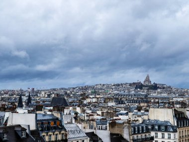 Paris downtown buildings over Montmartre Sacre Coeur Cathedral on moody weather day