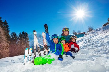 Three kids Family on ski vacation mother with children sit together in the snow over Mont Blanc French Aps summit