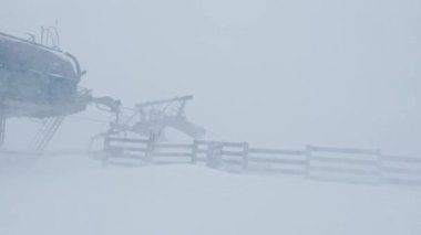 Şiddetli kar yağışı, kötü hava koşullarında dağlardaki kayak merkezinin üzerinde güçlü rüzgarla esiyor.