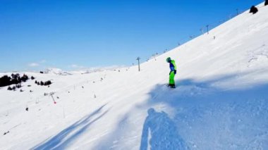  boy in action on snowboard slide down the slope in Alps mountain peaks on background