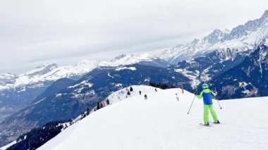 Child ride on ski slope downhill on beautiful mountain range with panorama French Alps Mont Blanc summits