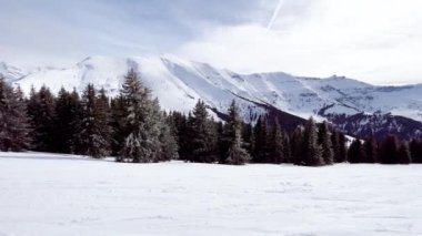 Güzel kar köknar ağaçlarını kaplamış Alp tatil köyünün hareket manzarası