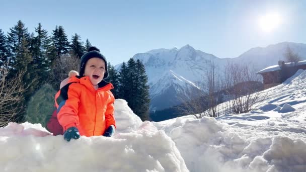 背景に山の上の雪の要塞で妹の遊びを持つ男の子 — ストック動画