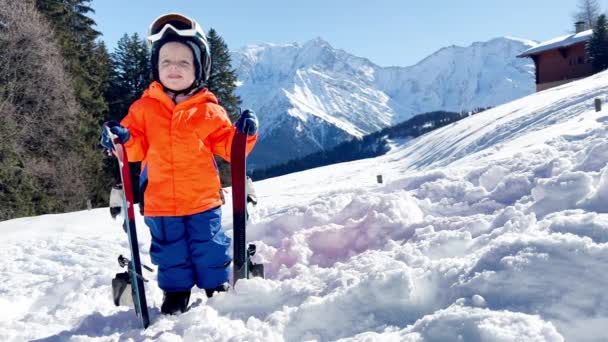 スキースクールの小さな男の子3歳の子供は背景に山の上に立つ — ストック動画