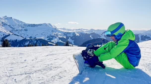 Närbild Pojken Fästa Snowboard Sitter Snön Skidspåret Och Sedan Utför — Stockvideo