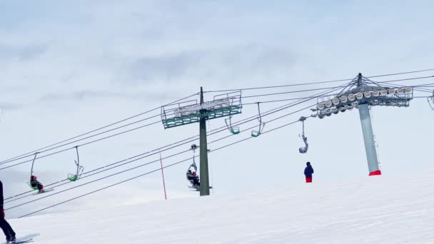 Widok Boczny Wyciągu Krzesełkowego Ośrodka Alpejskiego Przejazdem Narciarzy Torze Śnieżnym — Wideo stockowe
