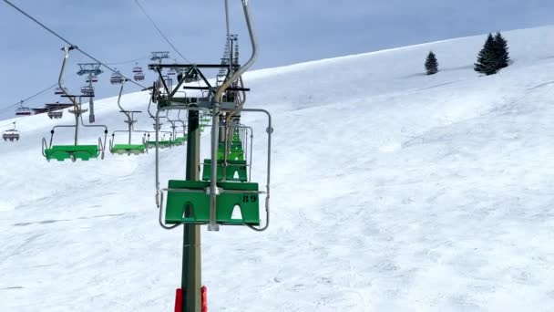 多くのスキーリフトチェアは青空の上に晴れた日に高山冬のリゾートでロープウェイに移動します — ストック動画
