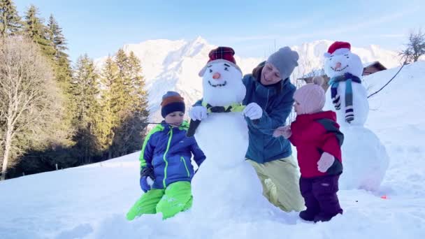 Family Mother Two Kids Snowmen Snow Mountain Background — Stok video