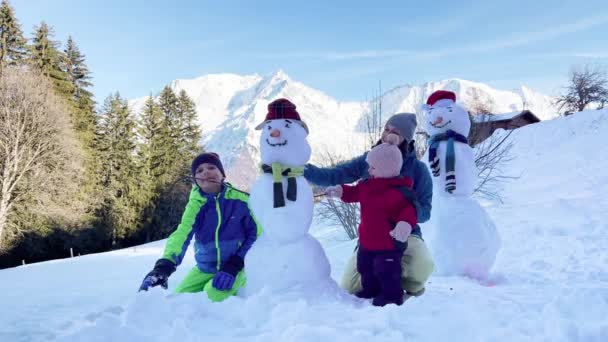Family Mother Two Kids Snowmen Snow Mountain Background — Stockvideo