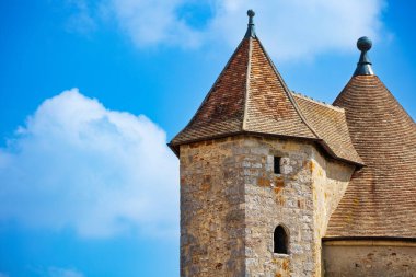 Beautiful close-up of medieval castle square towers over blue sky, Blandy-les-Tours, France