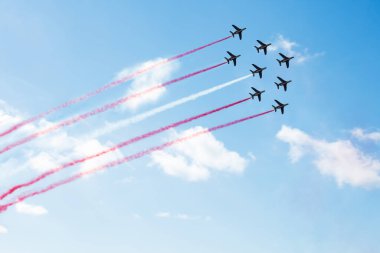 Squadron of planes fly with color trail lines of Poland Singapore Peru Monaco Malta Latvia Indonesia Denmark Austria over clouds and clear sky