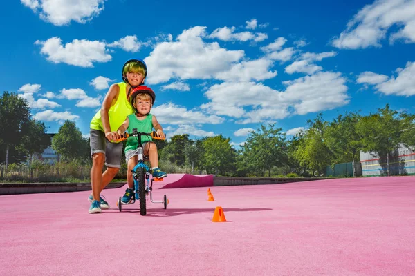 Preteen Boy Help Little Brother Learn Ride Bicycle Pushing Bike — Stock Photo, Image