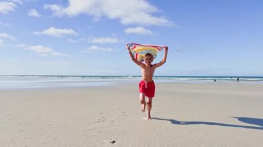 boy run with a colorful kite over the sea and beach, action motion dynamic concept