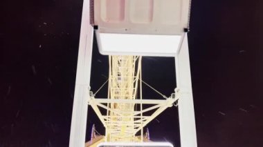 Huge beautiful Ferris wheel illuminated attraction rotating over night sky