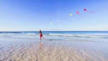 boy run with a colorful kite over the sea and beach, action motion dynamic concept