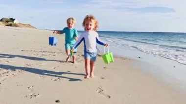 Two happy little kids  run on the sand beach  on summer vacation 