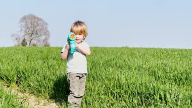 Portrait of a laughing blond happy boy at field in spring 