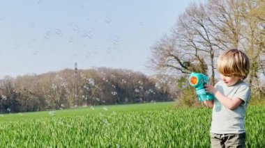 Portrait of a laughing blond happy boy at field in spring 