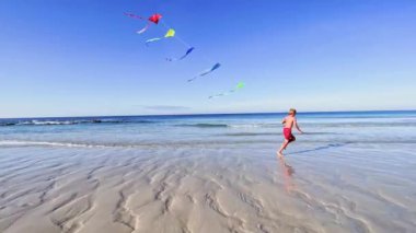 boy run with a colorful kite over the sea and beach, action motion dynamic concept