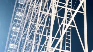 Huge beautiful Ferris wheel illuminated attraction rotating over night sky