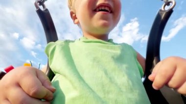 Çocuk parkında salıncakta sallanıyor. 