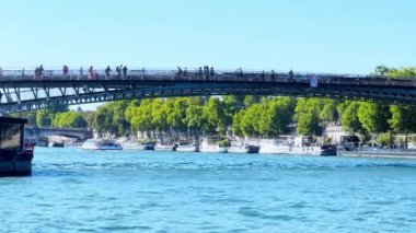 Paris 'teki Pont des Arts köprüsü, sıcak yaz gününde Seine nehrinin manzarası.