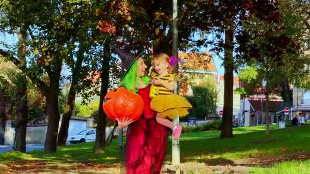 Retrato Madre Sosteniendo Niña Hermosa Con Cubo Para Truco Caramelos — Vídeo de stock