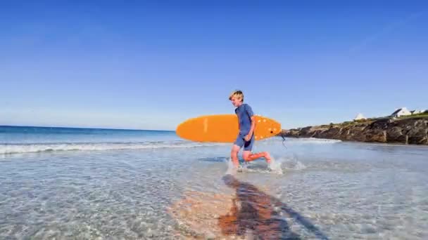 Słodkie Młody Chłopiec Strój Kąpielowy Spacer Trzymając Pomarańczowy Deska Surfingowa — Wideo stockowe