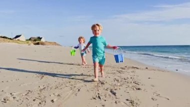 Two happy little kids  run on the sand beach  on summer vacation 