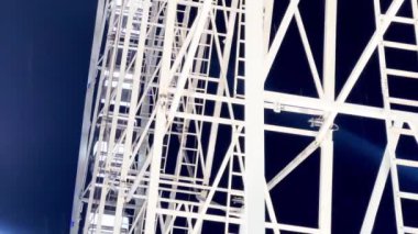 Huge beautiful Ferris wheel illuminated attraction rotating over night sky