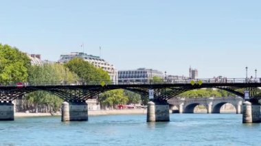 Paris 'teki Pont des Arts köprüsü, sıcak yaz gününde Seine nehrinin manzarası.